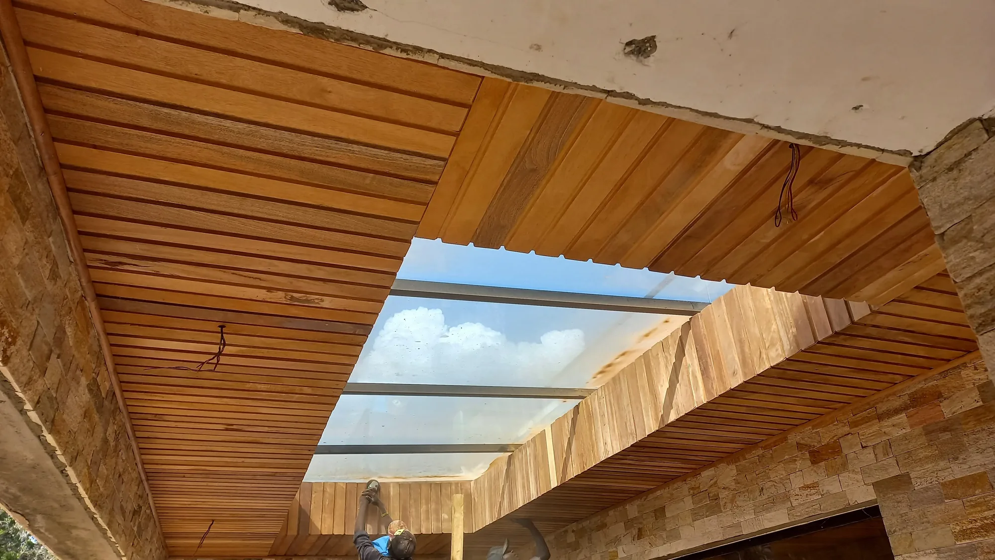 House of Wood and Marble — construction site view showing structural elements and exterior cladding at an intermediate stage
