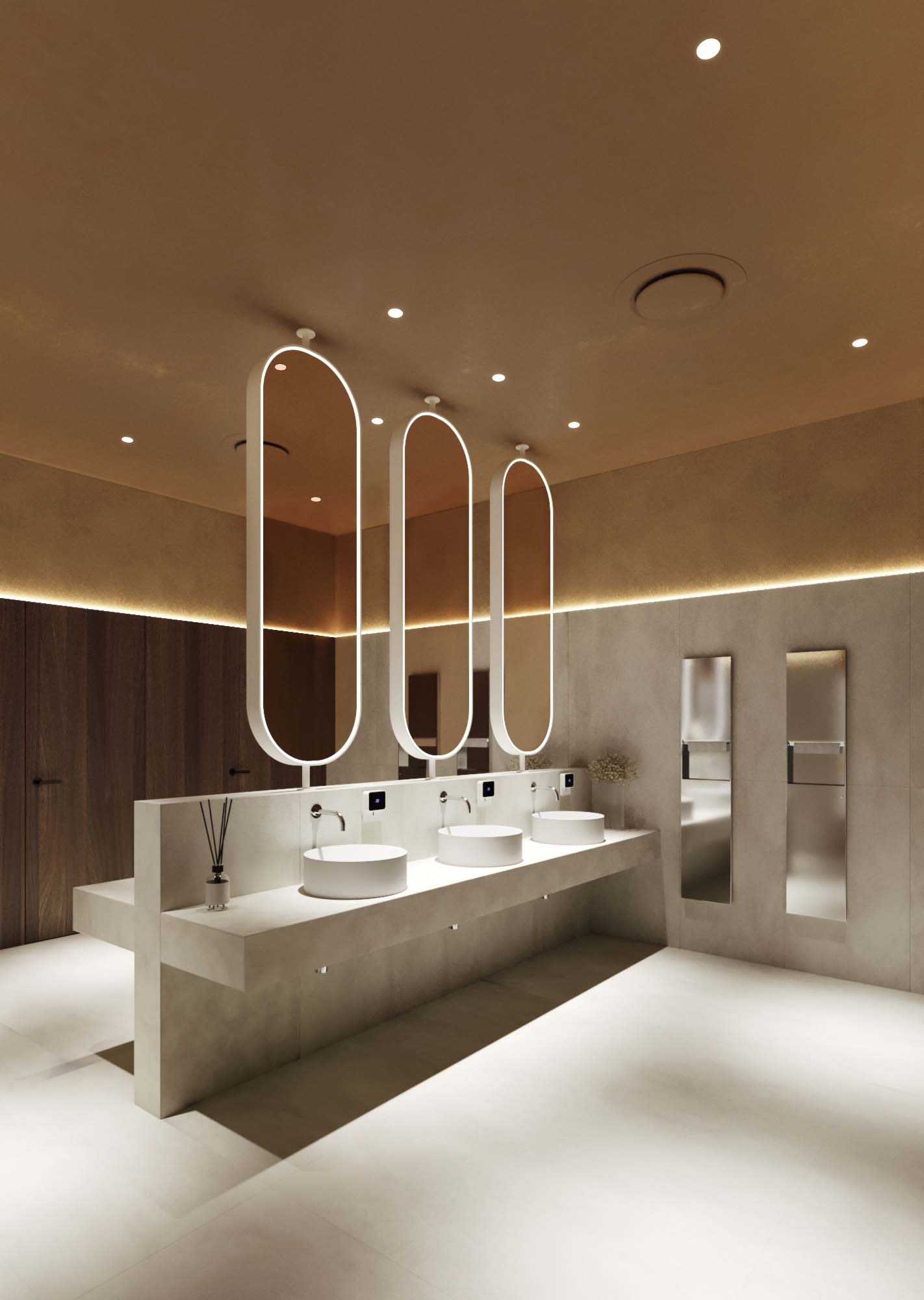 Cinema — washroom with three oval freestanding backlit mirrors on a long white stone vanity and warm recessed ceiling lighting