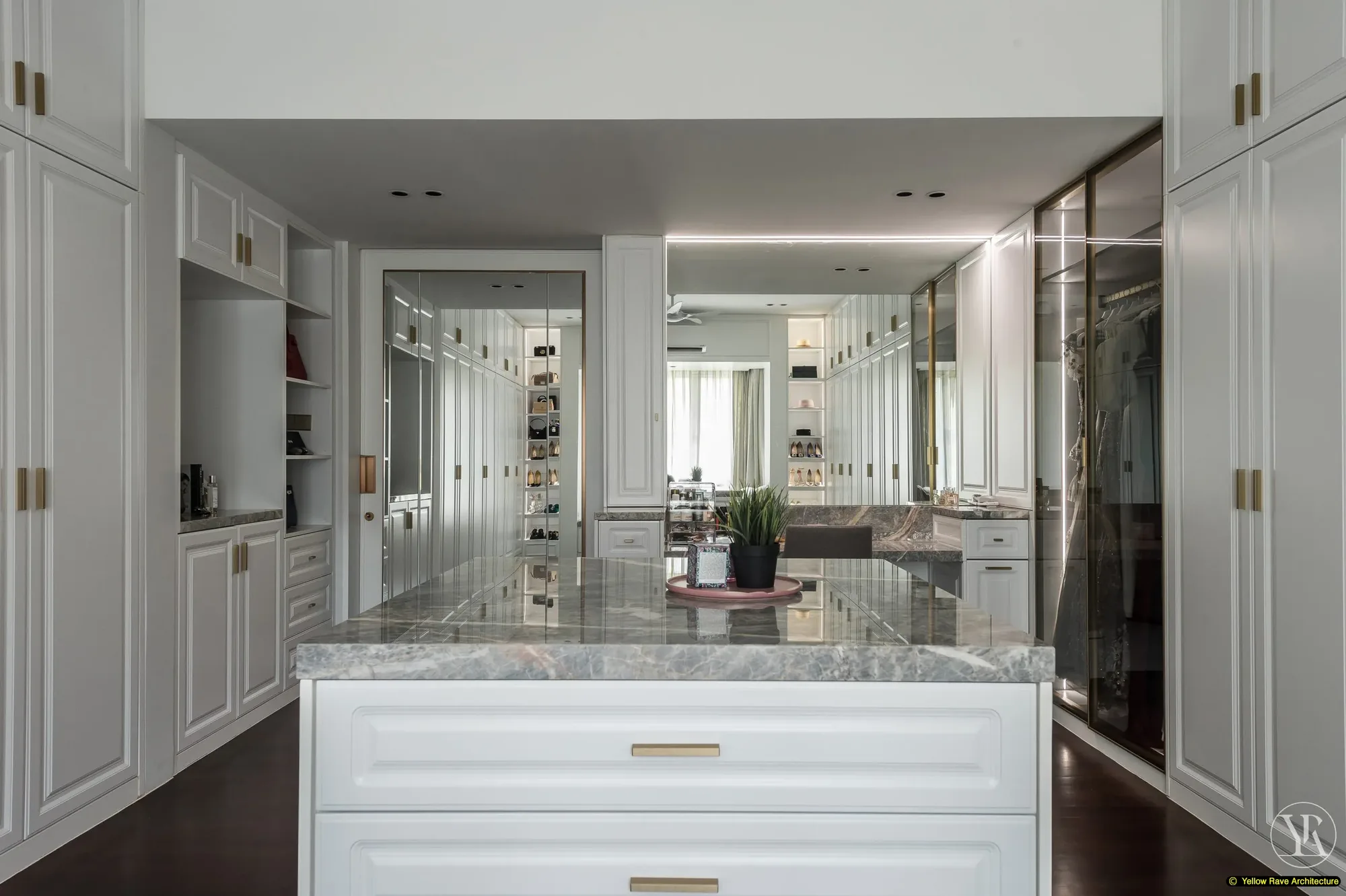 Pristine Walk-in Closet — view through sliding glass door into hanging rail zone with clothing visible, white panel cabinetry to either side