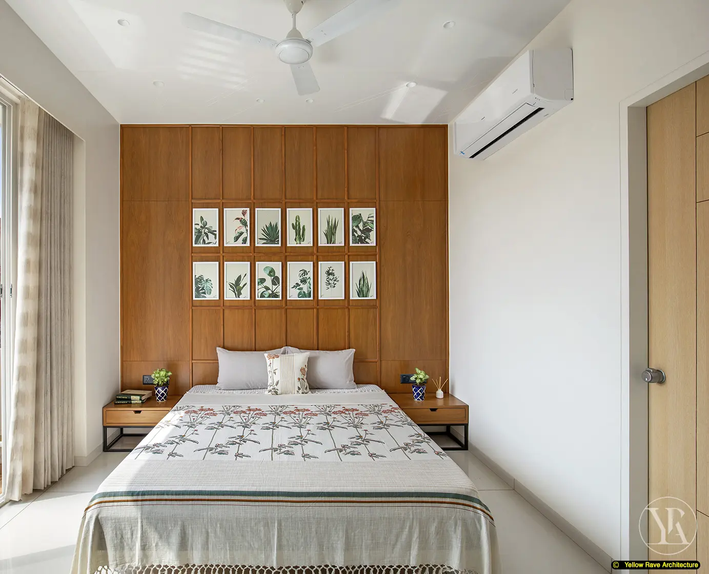 Nyali Apartment — living room wide-angle view showing green leather sofa, woven armchair, timber TV wall and open dining area with kilim rug in foreground