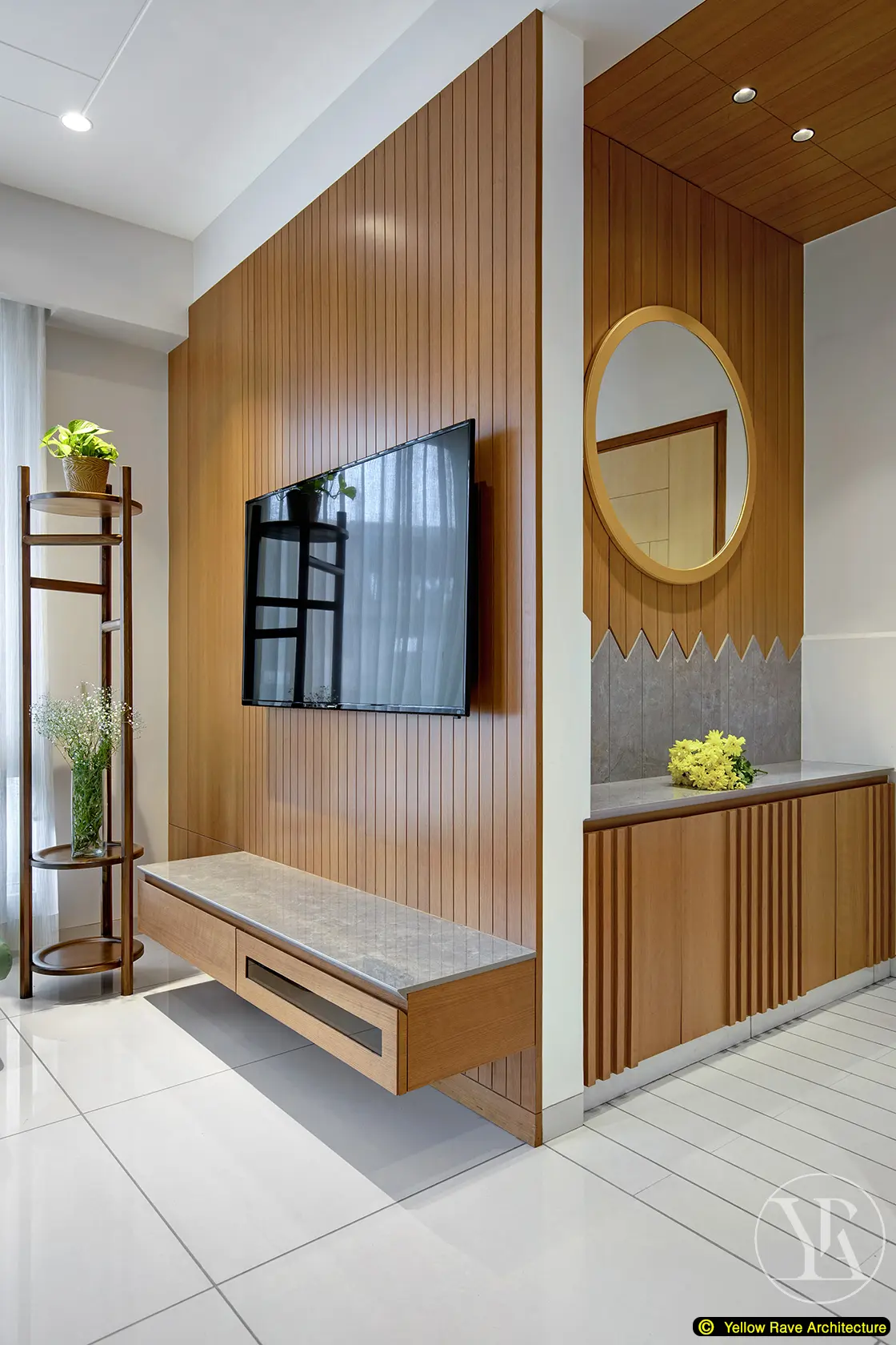 Nyali Apartment — full open-plan view from dining area toward living room and glazed balcony beyond, timber batten wall and green sofa visible