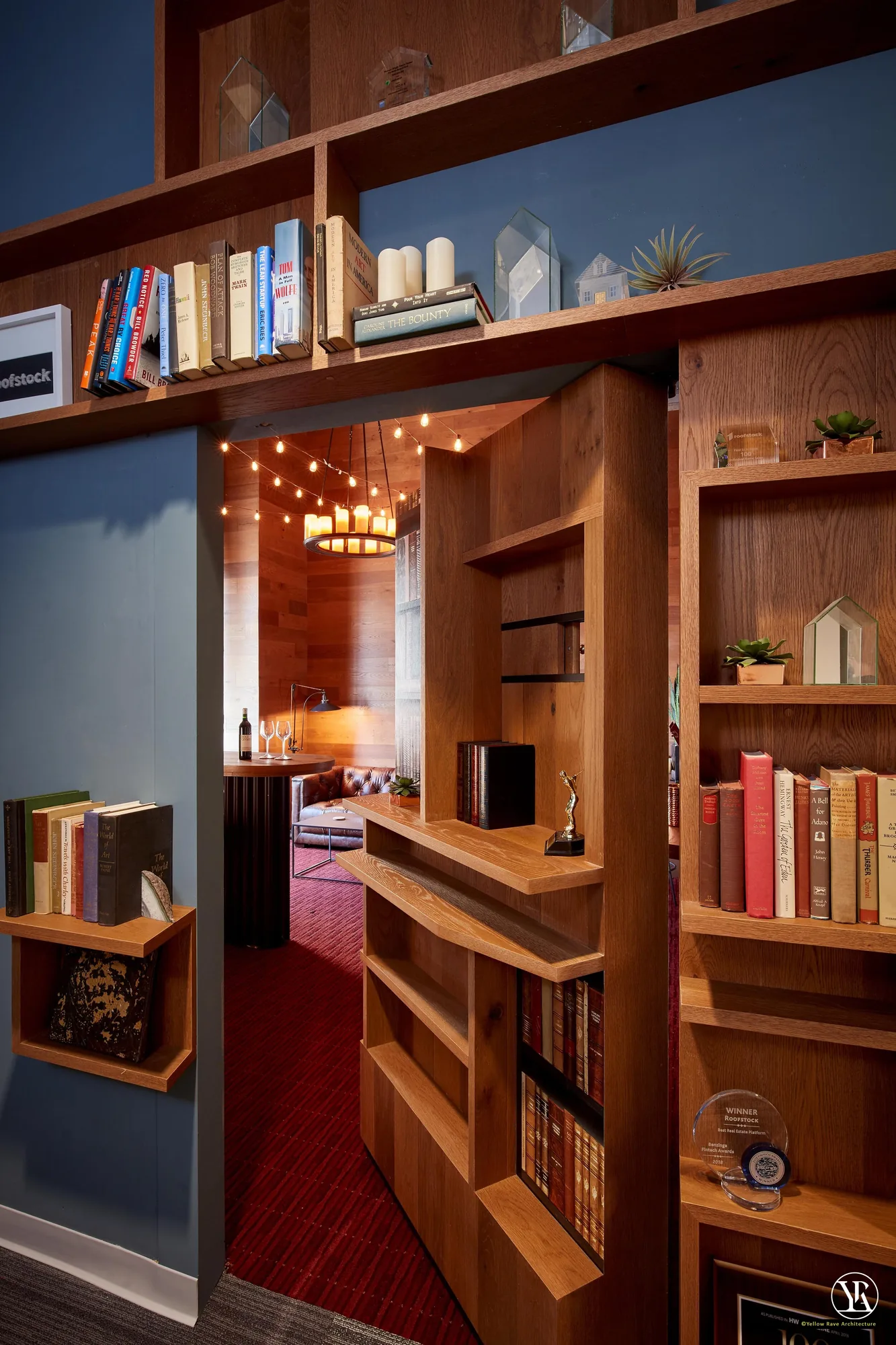 Man Cave — bar counter with timber top and curved end, black iron bar stools, spirits wall shelf, wine rack and French poster on dark grey wall
