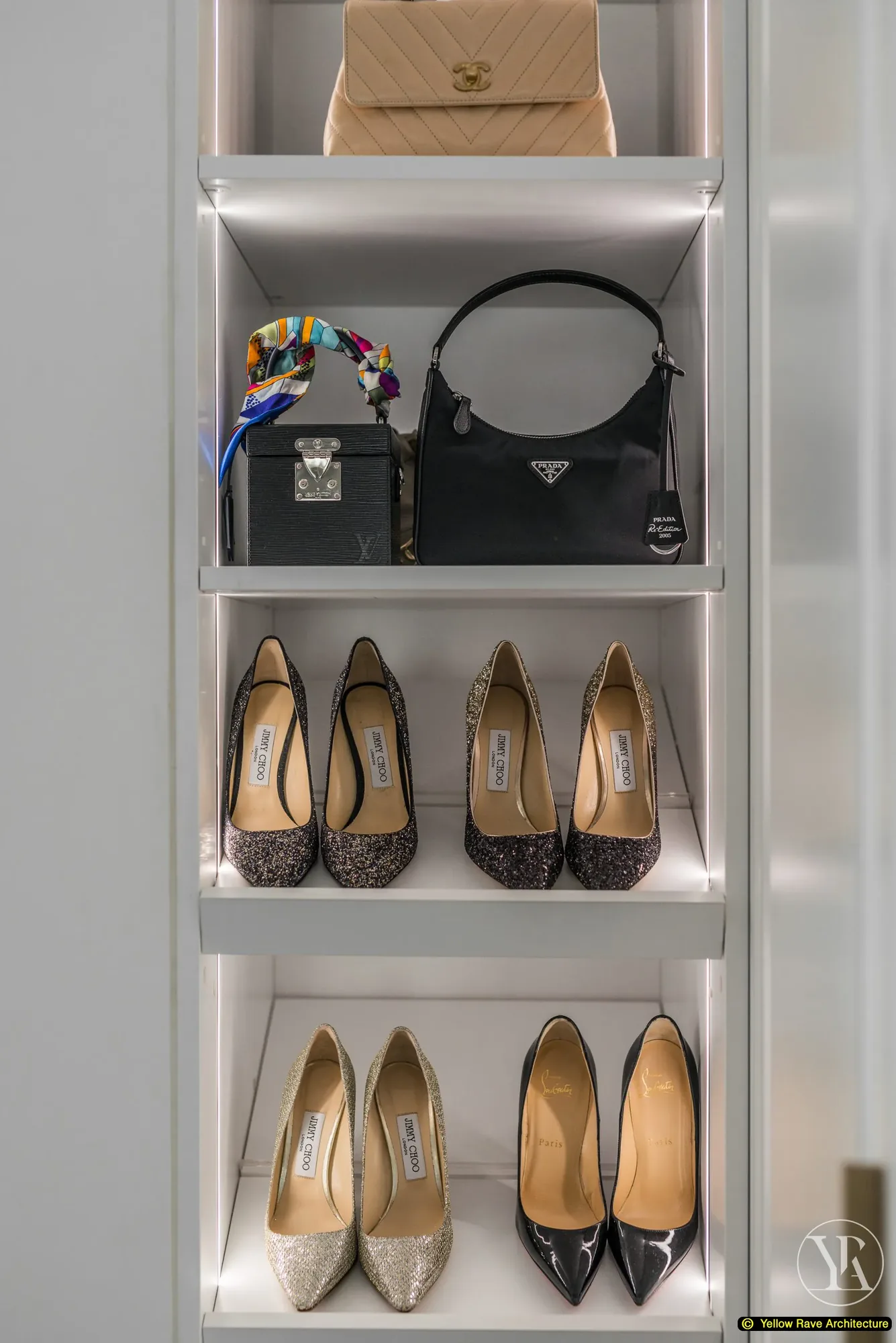 Pristine Walk-in Closet — island with grey veined marble top, open display shelving with shoes and handbags, white panel-moulded cabinets and full-height mirror beyond