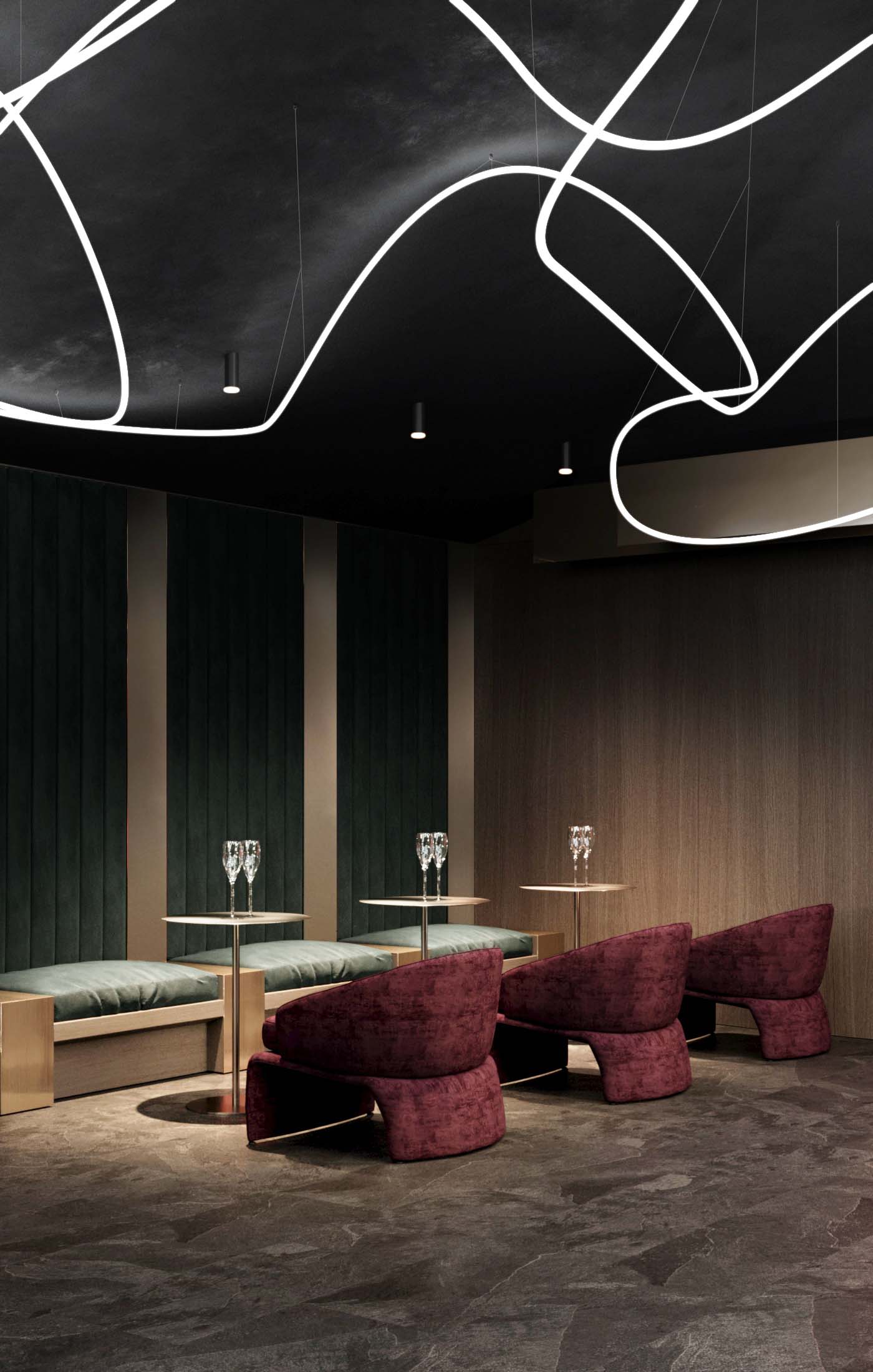Cinema — full-width hall with tan and grey tiered lounge seating and floor-to-ceiling LED strip acoustic panels on both sides