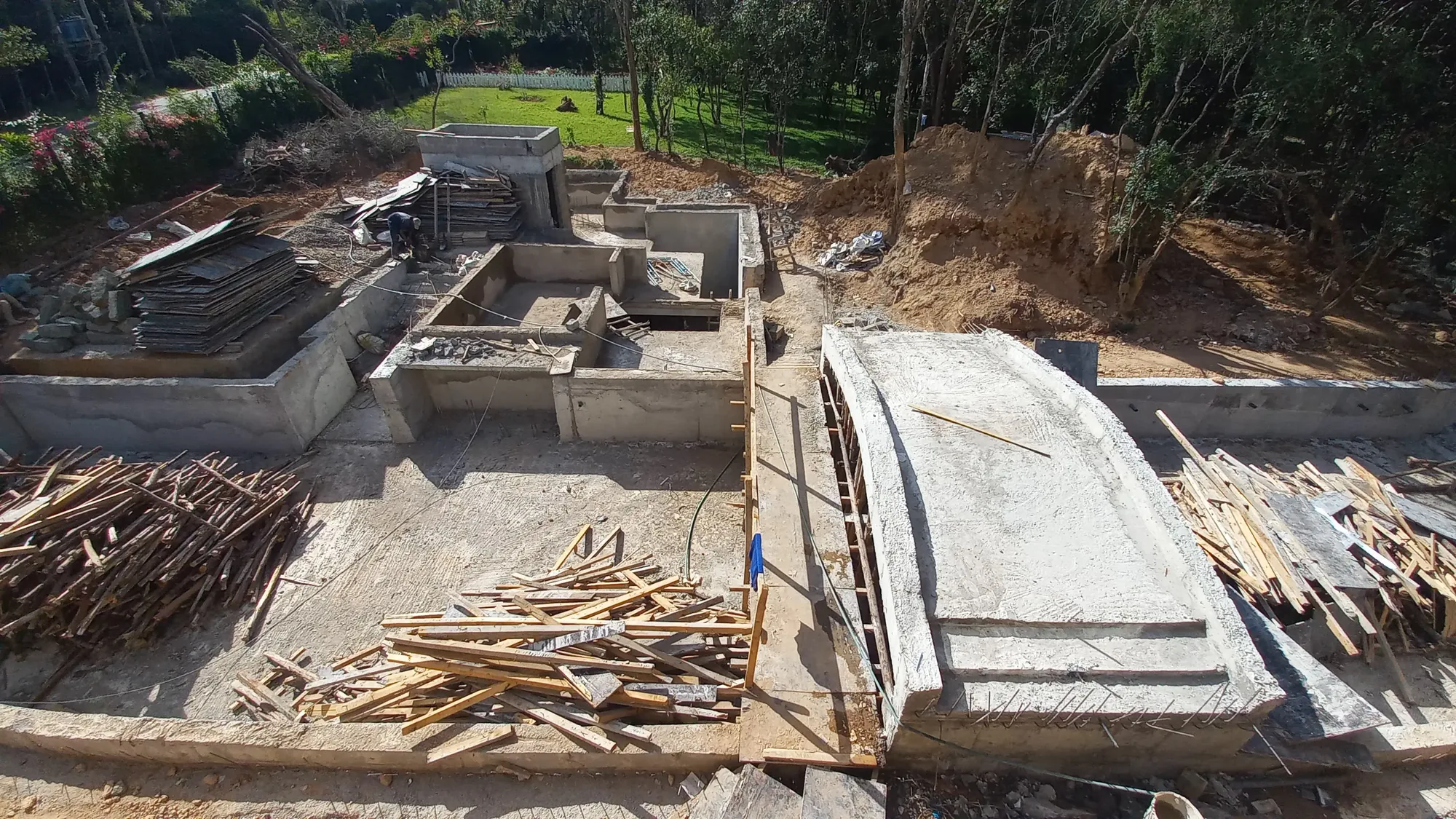 House of Wood and Marble — exterior site view showing the building form emerging from the Runda landscape