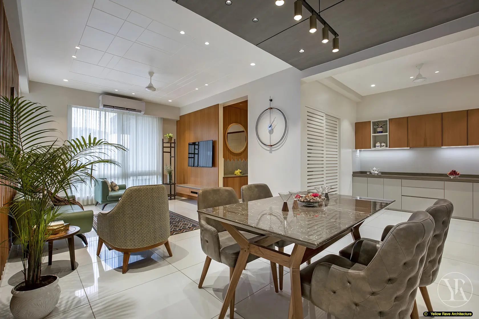 Nyali Apartment — open-plan dining and kitchen view with marble-top dining table, tufted chairs, kitchen with timber upper cabinets, and master bedroom visible through doorway