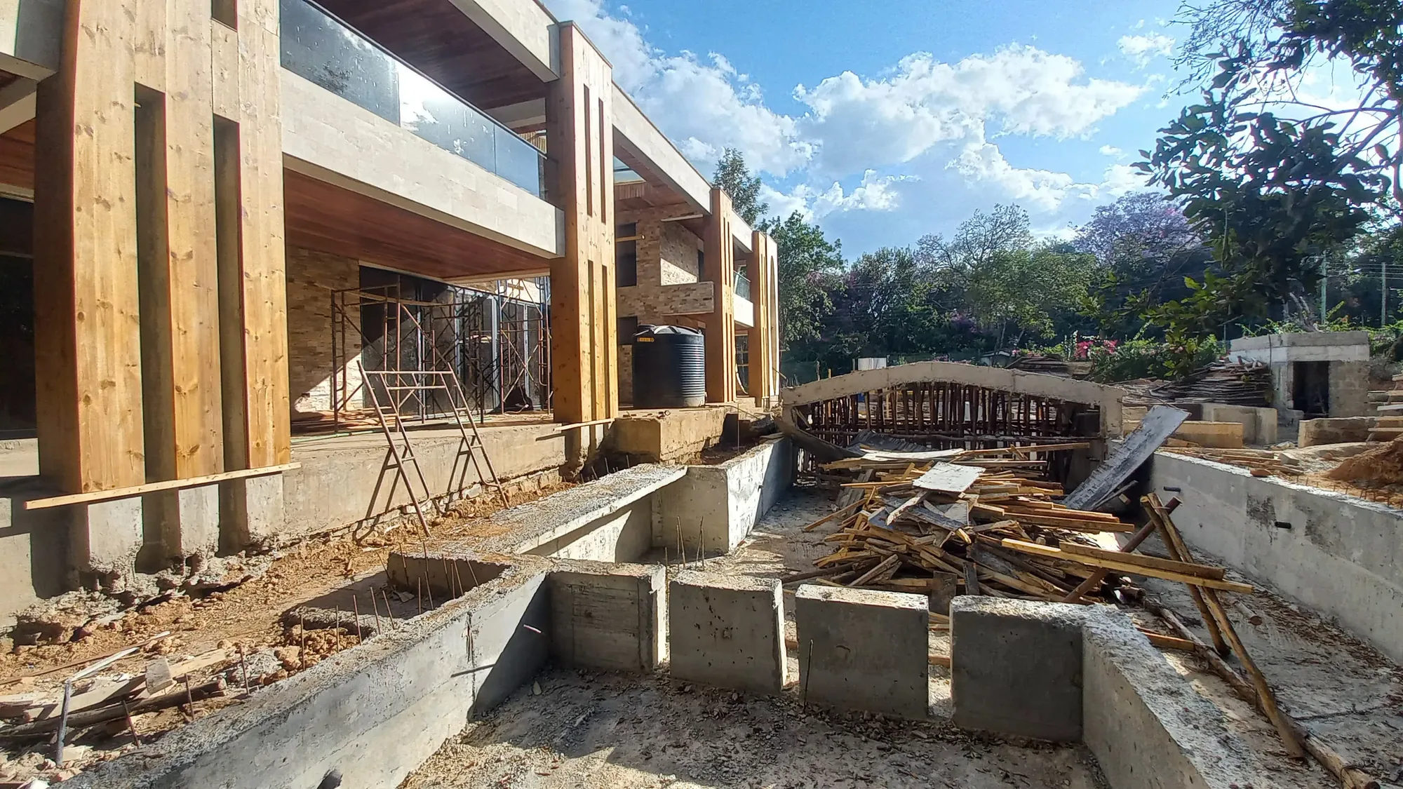 House of Wood and Marble — final construction view showing the completed stone facade and entry elements, Runda, Nairobi
