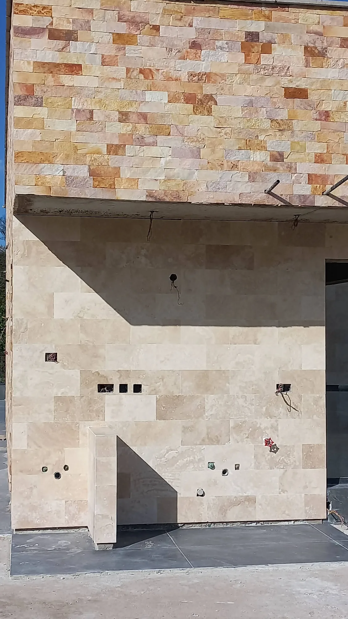 House of Wood and Marble — exterior detail showing stone wall and timber window frame elements at an advanced construction stage