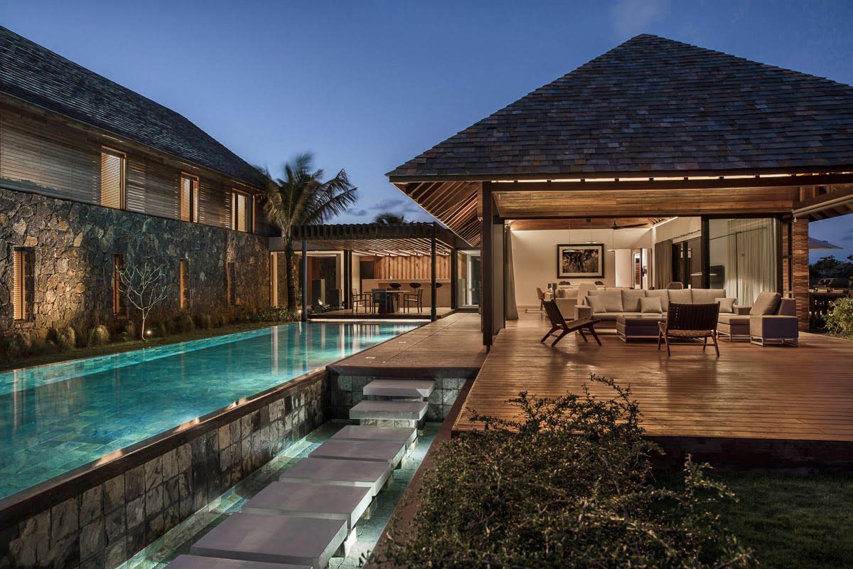 Serenity Abode — dusk exterior showing the first pavilion volcanic stone base and warm interior lighting