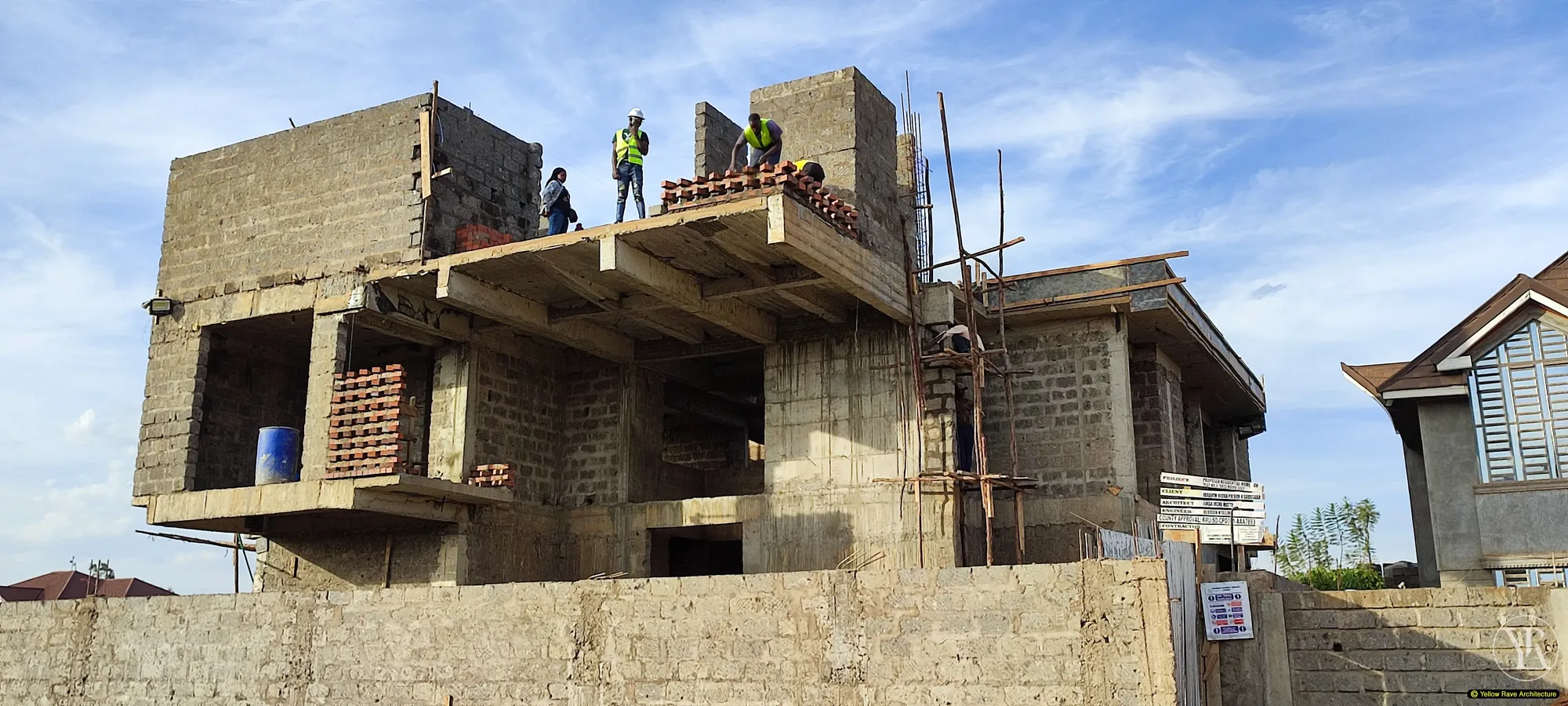 Yellow Rave Architecture — two-storey residential building under construction, masonry block walls and first-floor slab in progress, Nairobi